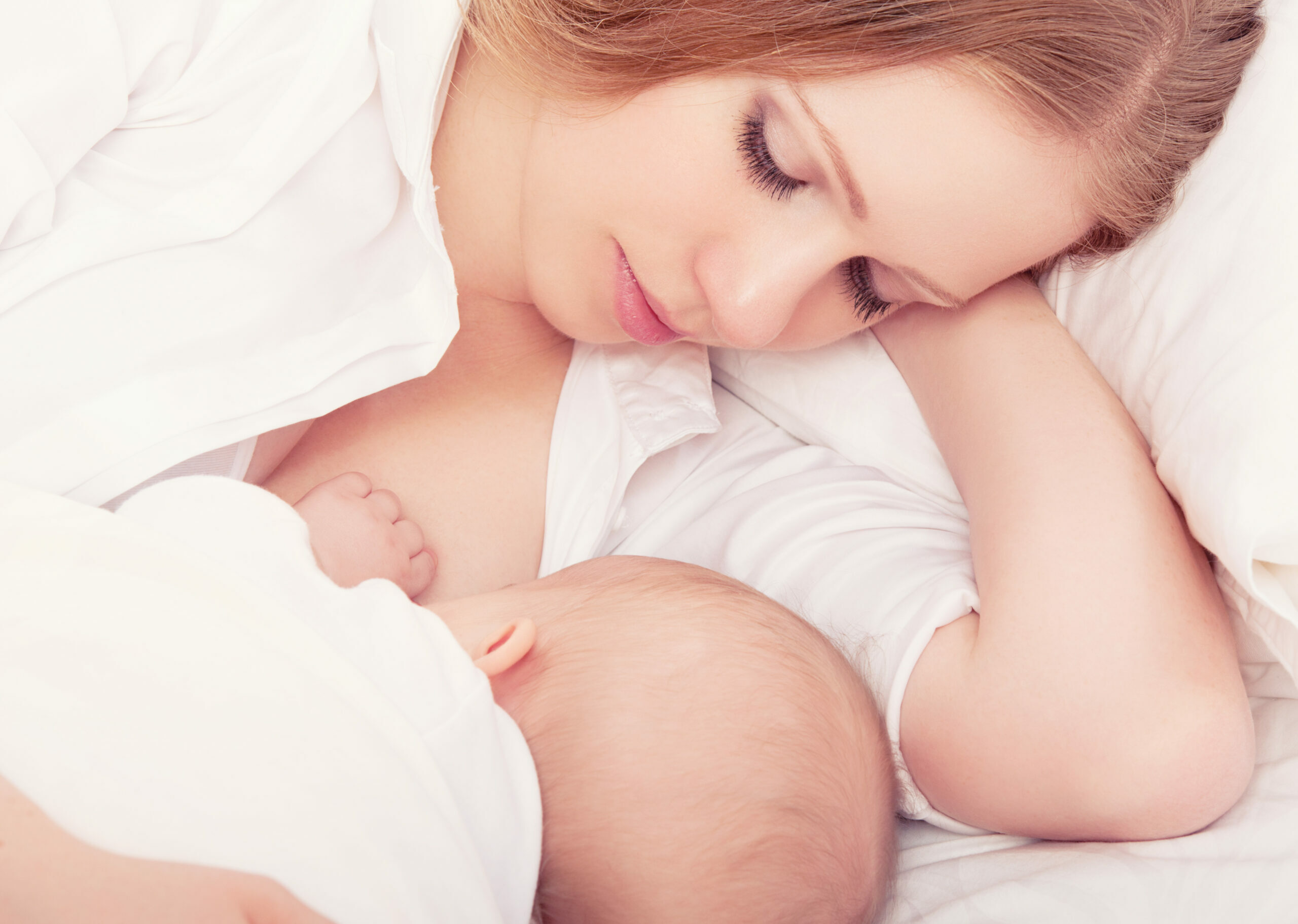 mother-feeding-her-baby-in-the-bed-sleeping-together